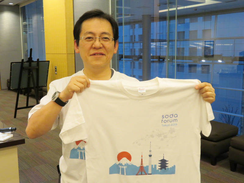 SODA ForumのTシャツを掲げる伊藤氏
