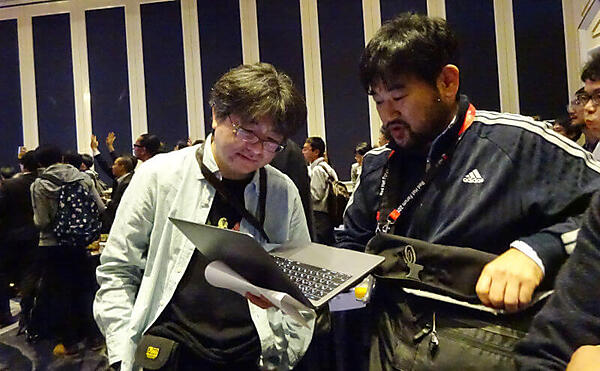 ノートPCを拡げて談笑するエンジニアたち