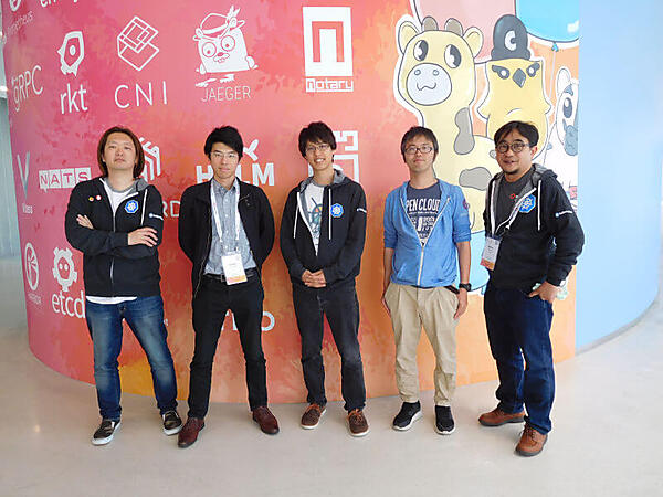 Kubernetes 5歳の誕生日を祝うイラストの前で。左から長谷川氏、徳永氏、青山氏、露崎氏、高良氏
