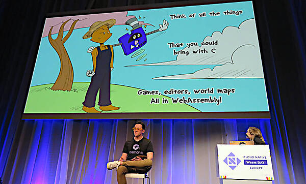 椅子に腰を掛けて絵本を朗読するTownsend氏。スライドを操作するのはBailey Hayes氏だ