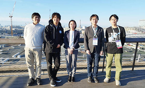 遠くに見えるエッフェル塔をバックに記念写真