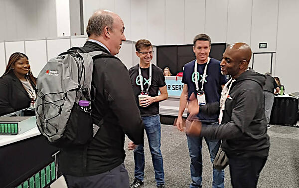 ブースを訪れたGoogleのKelsey Hightower氏（右）とOxideのCTO兼創業者のBryan Cantrill氏（左から2人目）