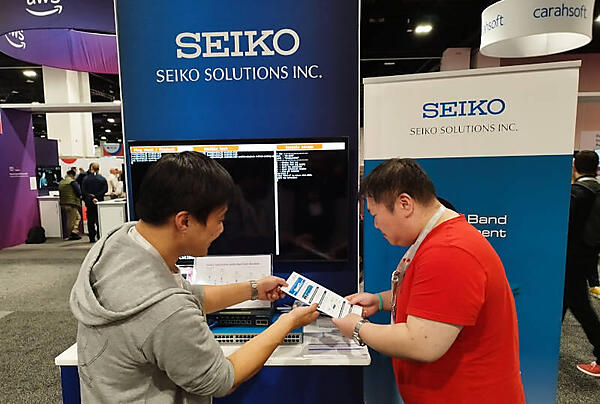 セイコーソリューションズのブース。文字が多めのスライドとマテリアルからまじめさが伝わってくる