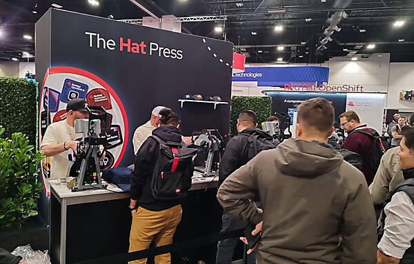 複数のステッカーから選択してベースボールキャップに貼り付ける作業を延々と続けるスタッフ