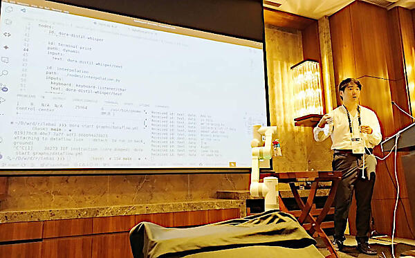 音声を使ってロボットアームを操作するTao氏。マイクから離れて音声が拾われない状況に