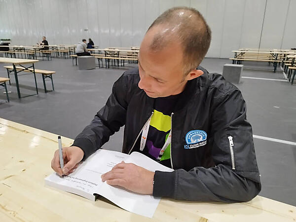 共著者となっている「Platform Engineering for Architects」にサインをするGrabner氏
